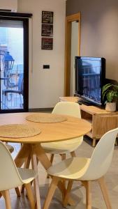 une chambre avec des tables, des chaises et une télévision dans l'établissement Pequeño loft para dos, à Sant Feliu de Guíxols