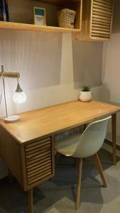 a wooden desk with a lamp and a chair at Pequeño loft para dos in Sant Feliu de Guixols +8 photos