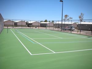 a tennis court with two people playing on it at Aspen Karratha Village in Karratha