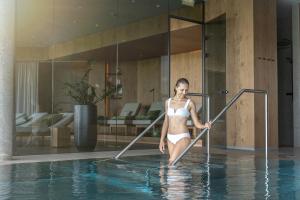 a woman in a bikini standing in a swimming pool at Loxone Campus in Kollerschlag