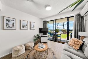 a living room with a couch and a tv at Hear the Sea 2 mins from Coolum beach and shops in Coolum Beach