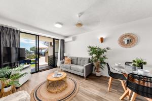 a living room with a couch and a table at Hear the Sea 2 mins from Coolum beach and shops in Coolum Beach