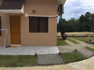 a house with a motorcycle parked outside of it at Gengs Apartment and Nmax Rentals in Dipolog