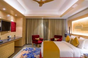 a hotel room with a bed and two chairs at Ananta Spa & Resort Jaipur in Jaipur