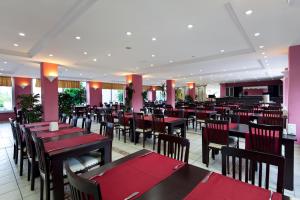un comedor con mesas y sillas rojas en Garden Park Beldibi Hotel en Beldibi