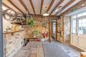 a large room with a stone wall and a door at Bridge End Mill Holiday Apartments by Guestz in Settle