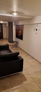 a living room with a couch and a clock on the wall at Keflavik Cozy Apartment in Keflavík