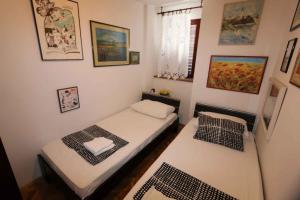 two beds in a small room with pictures on the wall at Holiday home in Silo/Insel Krk 26681 in Šilo