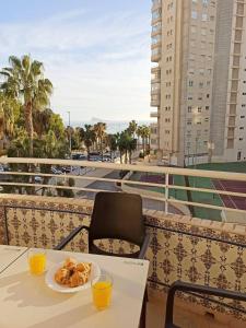 a table with a plate of food on a balcony at Olivar Beach by Agencia Poniente in Benidorm