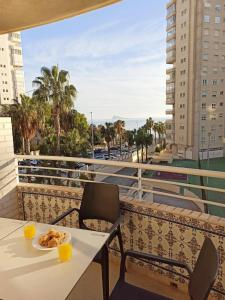 a table with a plate of food on a balcony at Olivar Beach by Agencia Poniente in Benidorm