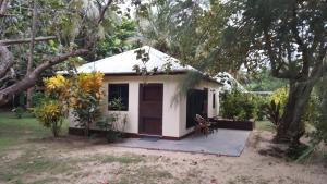 una pequeña casa blanca con un porche en un patio en Yasawa Long Beach Hideout Resort en Vuake