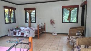 a bedroom with a bed and a chair and windows at Yasawa Long Beach Hideout Resort in Vuake