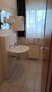ein Bad mit einem Waschbecken und einem Fenster in der Unterkunft Haus Südstrand in Göhren