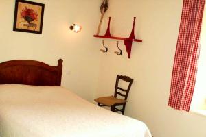 1 dormitorio con 1 cama, 1 silla y 1 ventana en Maison d'une chambre avec spa jardin amenage et wifi a Plouegat Moysan en Plouégat-Moysan