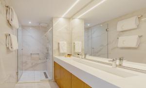 a bathroom with two sinks and a shower at Golden Bay Beach Hotel in Larnaca