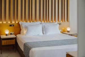 a bedroom with a bed with white sheets and pillows at Golden Bay Beach Hotel in Larnaca