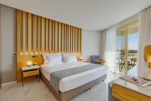 a hotel room with a bed and a balcony at Golden Bay Beach Hotel in Larnaca