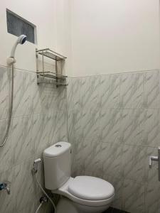 ein Bad mit einem WC und einer Dusche in der Unterkunft Resy home syariah dekat alun2 wonosobo in Kalianget