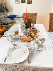 mesa de comedor con platos blancos y velas rojas en Istebna 401 MURY, en Istebna