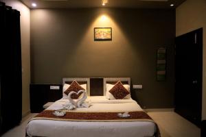 a bedroom with a large bed with white sheets at Hotel Pushkar Legacy in Pushkar