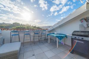 a balcony with a table and chairs and a stove at Il Porto 25 Mansarda sul Mare - Goelba in Porto Azzurro