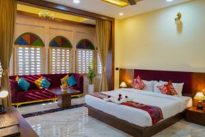 a bedroom with a large bed and a couch at Hotel Pushkar Legacy in Pushkar