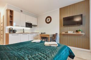 シフィノウイシチェにあるPegaz Apartments by Baltic Homeのベッドルーム(緑色のベッド1台、デスク付)