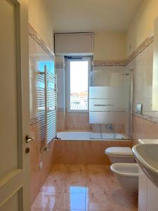 bagno con 2 servizi igienici, vasca e lavandino di Porta Vittoria Apartments by Accomodo a Milano