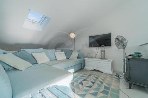 a living room with a blue couch and a tv at Il Porto 25 Mansarda sul Mare - Goelba in Porto Azzurro