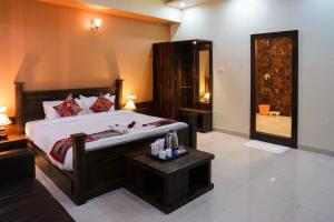 a bedroom with a large bed with a table and a door at Hotel Pushkar Legacy in Pushkar
