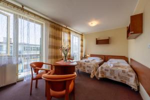 a hotel room with two beds and a table and chairs at OW Carbo w sąsiedztwie lasu i jeziora in Dąbki