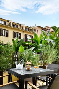stół z jedzeniem i kieliszkami do wina na balkonie w obiekcie Margutta 19 - Small Luxury Hotels of the World w Rzymie
