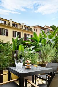 a table with food and wine glasses on a balcony at Margutta 19 - Small Luxury Hotels of the World in Rome