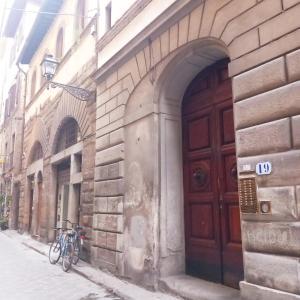 ein Fahrrad, das neben einem Gebäude mit einer Holztür parkt in der Unterkunft Appartamento centro storico Firenze, Luna House in Florenz
