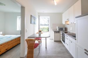 a kitchen with a table and a bed in a room at Achtern Diek in Dagebüll
