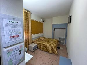 een kleine slaapkamer met een bed en een bord bij Hotel Il Parco in Grosseto