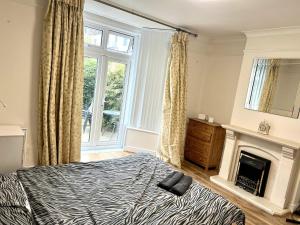a bedroom with a bed and a fireplace at Detached 4-Bed House near Heathrow in Egham