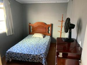 um quarto com uma cama e uma cómoda com uma ventoinha em Samambaia 01 em Brasília