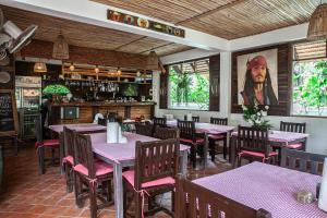 a restaurant with tables and chairs and a picture of a man at Lanta Thai Homestay in Ko Lanta