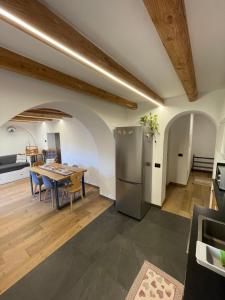 eine Küche und ein Esszimmer mit einem Tisch und einem Kühlschrank in der Unterkunft Appartamento Gioia di Bosco in Carano