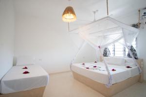 1 dormitorio con 2 camas con flores en Weber Zazu - Maisha Resort, en Watamu