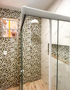 um chuveiro com uma porta de vidro na casa de banho em Ótimo studio c WiFi a 190m da Praia do Leme - RJ no Rio de Janeiro