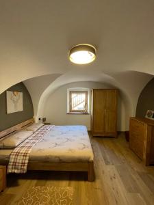 ein Schlafzimmer mit einem großen Bett und einem Fenster in der Unterkunft Appartamento Gioia di Bosco in Carano