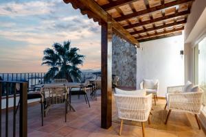 a patio with a table and chairs on a balcony at Villa Los Primos in Calonge