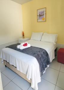 een slaapkamer met een groot wit bed met bloemen erop bij POUSADA CAMINHO do MAR in Pôrto de Pedras