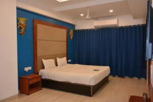 - une chambre dotée d'un lit avec un mur bleu dans l'établissement The Grand Neelam, à Phundardih