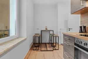 a kitchen with a counter and stools in it at Frisch renovierte Wohnung - Zentral/Ruhig/Modern in Augsburg