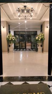 a lobby with two flowers in vases in a building at เอวา โฮเทล อุดรธานี (AVA Hotel Udonthani) in Ban Chang