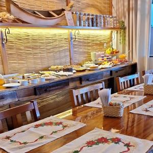 a table with chairs and a buffet with food at NAVEGA HOUSE in Navegantes