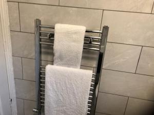 een handdoekenrek in een badkamer met 2 handdoeken bij Comfort Home From Home Bolton Central Hilden St - Sleeps - 10 in Bolton